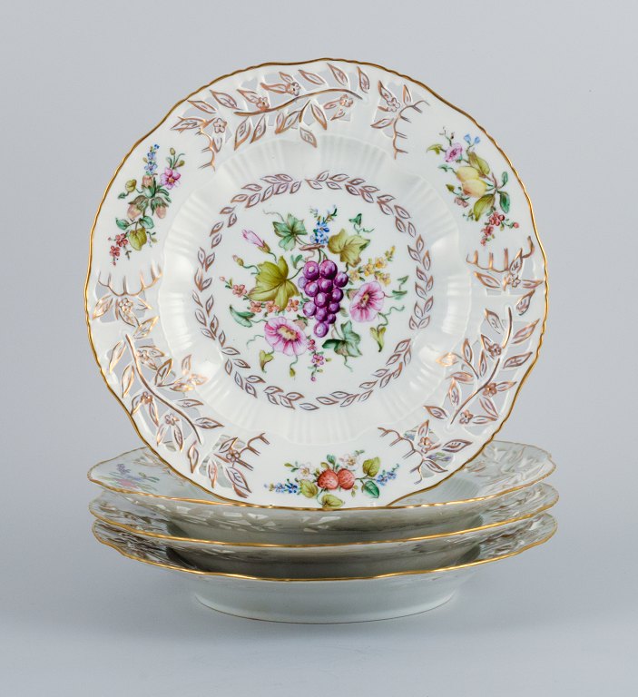 Royal Copenhagen, a set of four antique dinner plates with reticulated rim and 
leaf work.