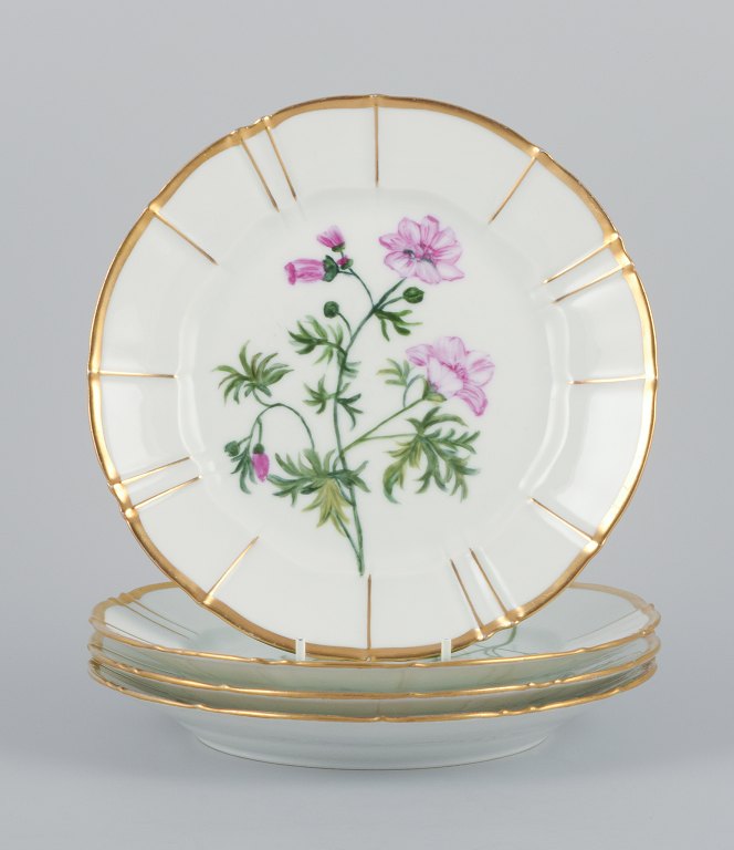 Bing and Grøndahl, four porcelain plates in Flora Danica style with gold 
decoration.