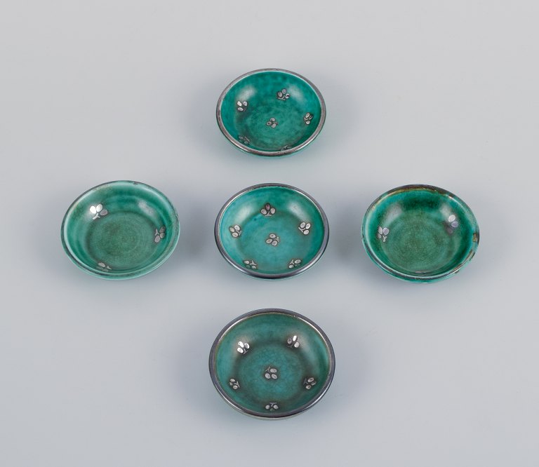 Wilhelm Kåge for Gustavsberg, a set of five small "Argenta" ceramic bowls. Green 
glaze with silver inlays.
