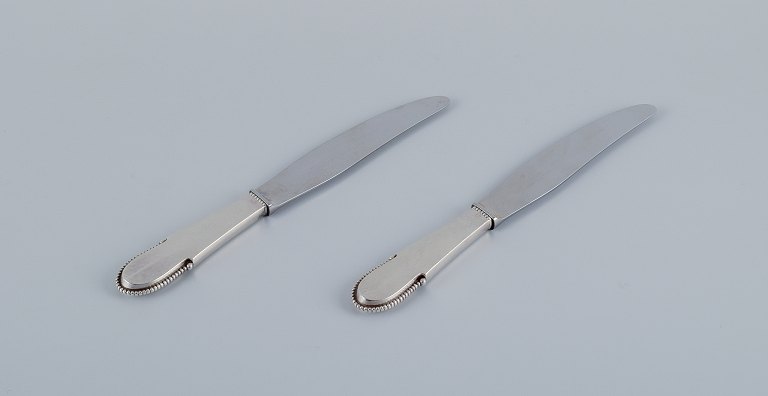 Georg Jensen Kugle. 
To kortskaftede middagsknive i sterlingsølv. Blad i rustfrit stål.