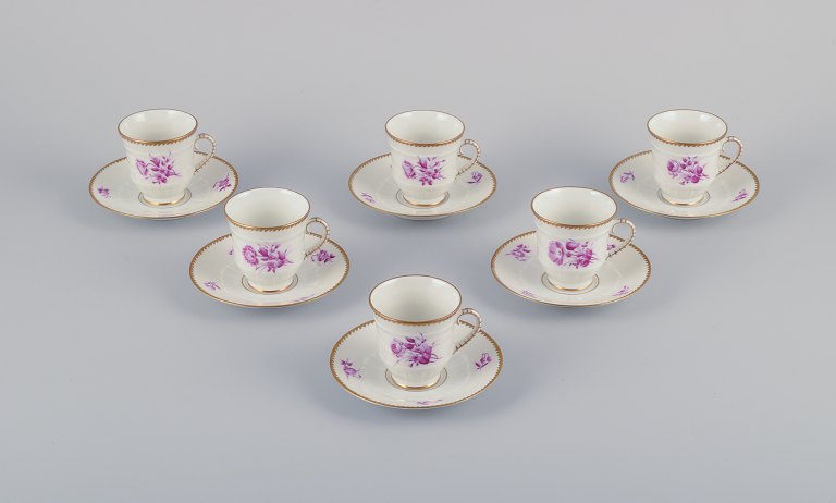 Bing & Grøndahl, Denmark. A set of six demitasse cups with saucers decorated 
with floral motifs in purple and gold trim. Hand-painted.