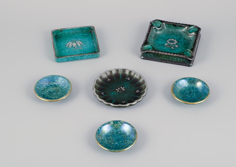Wilhelm Kåge & Josef Ekberg for Gustavsberg, Sweden. A set of six ceramic dishes 
in different sizes. Flower motifs inlaid in silver.