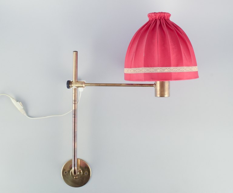 Hans Agne Jakobsson, Swedish designer. Wall lamp in brass with a lampshade in red fabric. Modernist design.