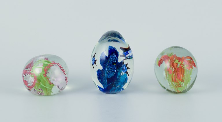 Scandinavian glass artist. Set of three paperweights in art glass. Flower motifs 
and more embedded in the glass. Handmade.