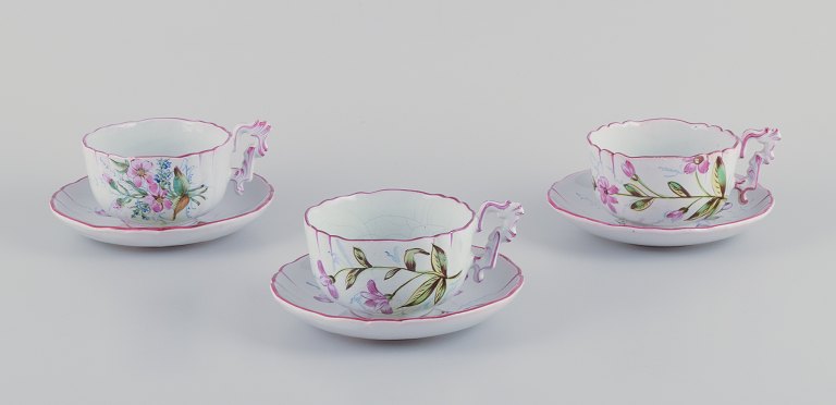 Emile Gallé (style of). Three hand-painted tea cups and saucers in faience with 
motifs of flowers and insects.