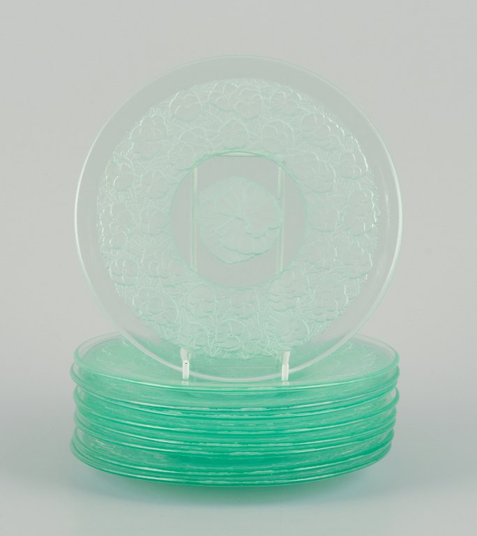 Lalique-style. A set of nine glass plates designed with flower motifs in green 
glass.