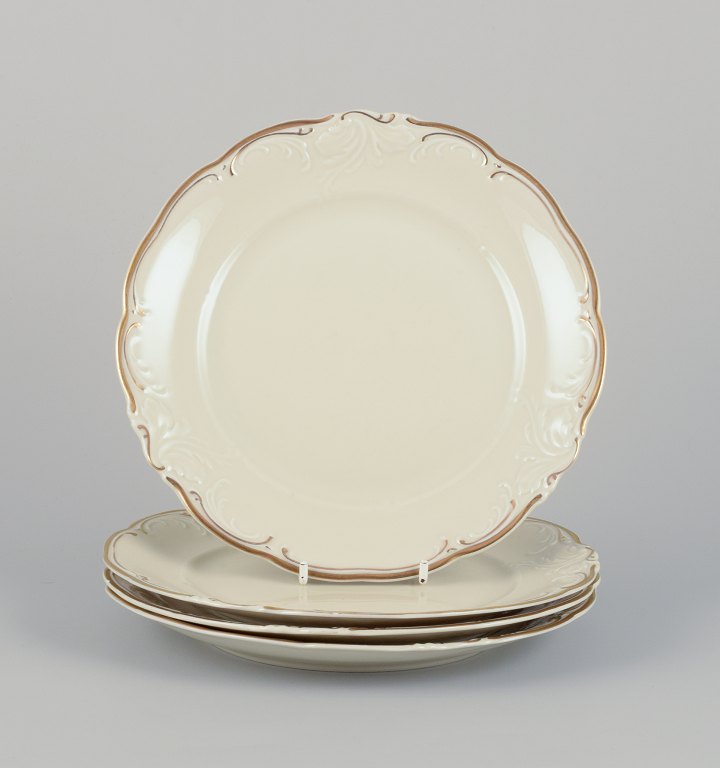 KPM, Poland. A set of four porcelain lunch plates.
Cream-colored with gold rim decoration.