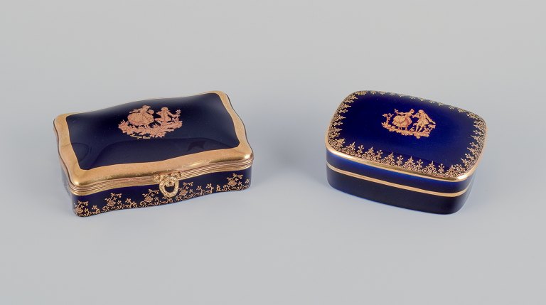 Limoges, France. Two porcelain covered boxes decorated with 22-karat gold leaf 
and beautiful royal blue glaze. Scène galante.