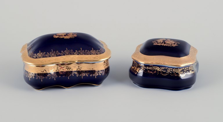 Limoges, France. Two lidded porcelain jars adorned with 22-karat gold leaf and 
featuring a beautiful royal blue glaze with a Scène galante.