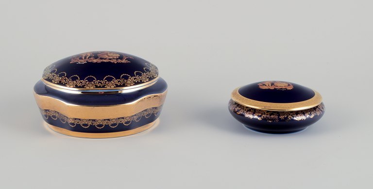 Limoges, France. Two lidded porcelain jars decorated with 22-karat gold leaf and 
a beautiful royal blue glaze. Scène galante.