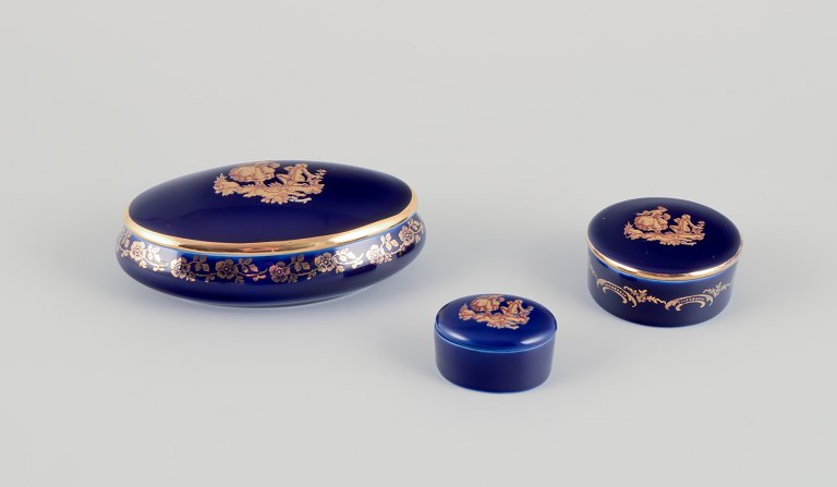 Limoges, France. Three miniature lidded jars in porcelain, decorated with 
22-karat gold leaf and a beautiful royal blue glaze. Scène galante.