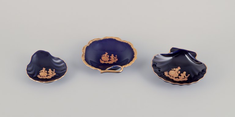 Limoges, France. Three bowls in porcelain decorated with 22-karat gold leaf and 
beautiful royal blue glaze. Scène galante.