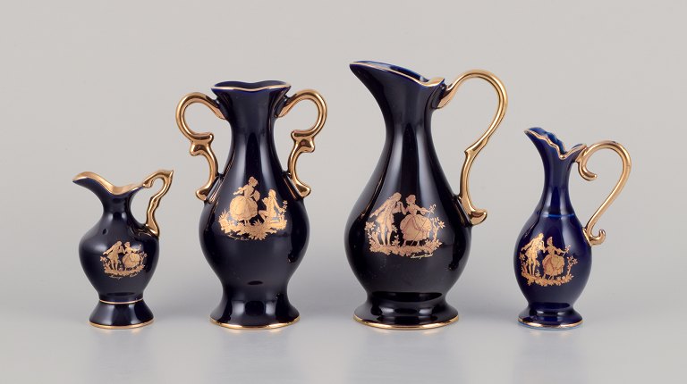 Limoges, France. Three pitchers and a vase in porcelain decorated with 22-karat 
gold leaf. Beautiful royal blue glaze. Scène galante.