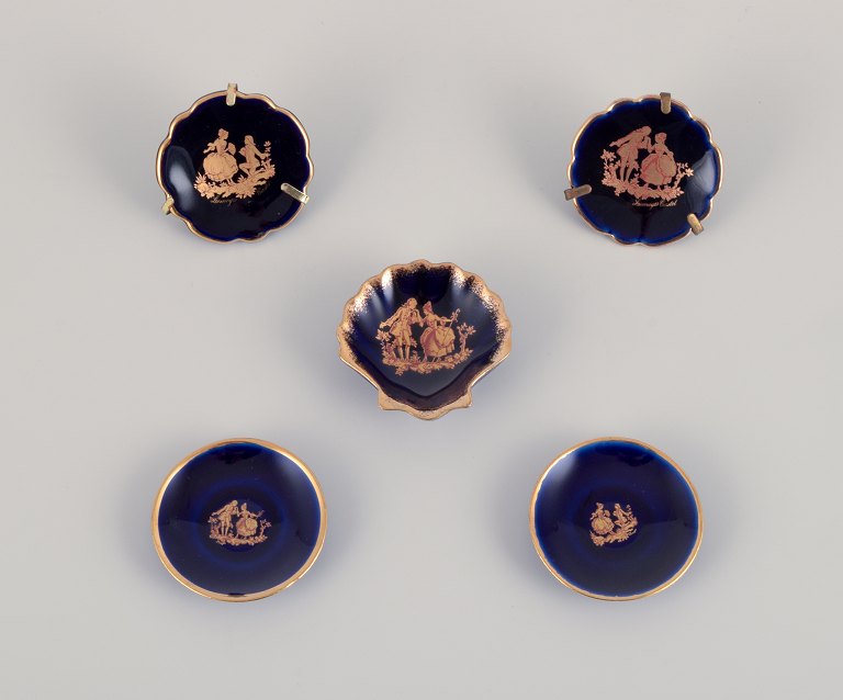 Limoges, France. Five small pieces of porcelain decorated with 22-karat gold 
leaf. Beautiful royal blue glaze. Scène galante.