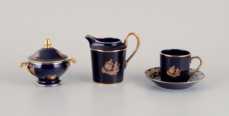 Limoges, France. Coffee cup, sugar bowl, and creamer in porcelain decorated with 
22-karat gold leaf and beautiful royal blue glaze. Scène galante.