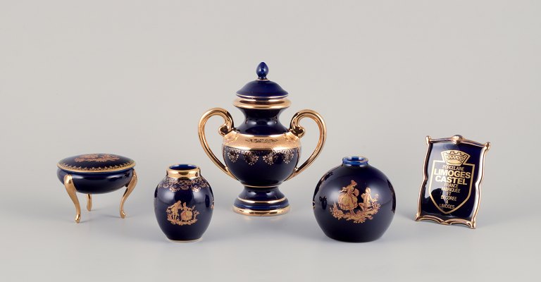 Limoges, France. Five pieces of porcelain consisting of a lidded jar, two vases, 
a lidded three-footed jar, and a dealer advertising sign. Decorated with 
22-karat gold leaf. Beautiful royal blue glaze.