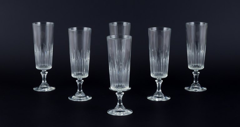 A set of six Swedish Champagne flutes in clear glass. Faceted.