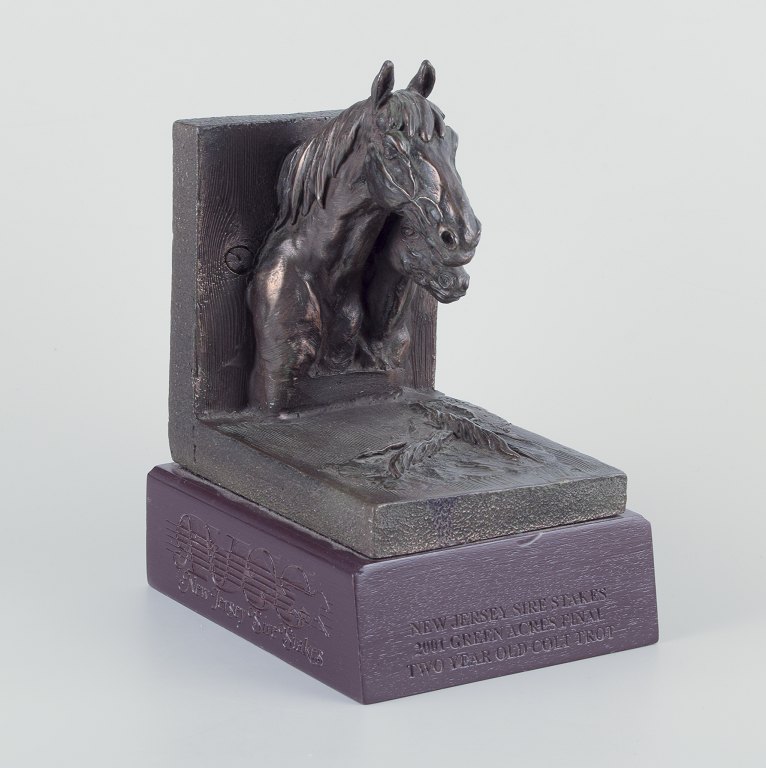Jeanne Patricia Rynhart (1946–2020), irsk billedhugger.
Bogstøtte i bronze på træsokkel.